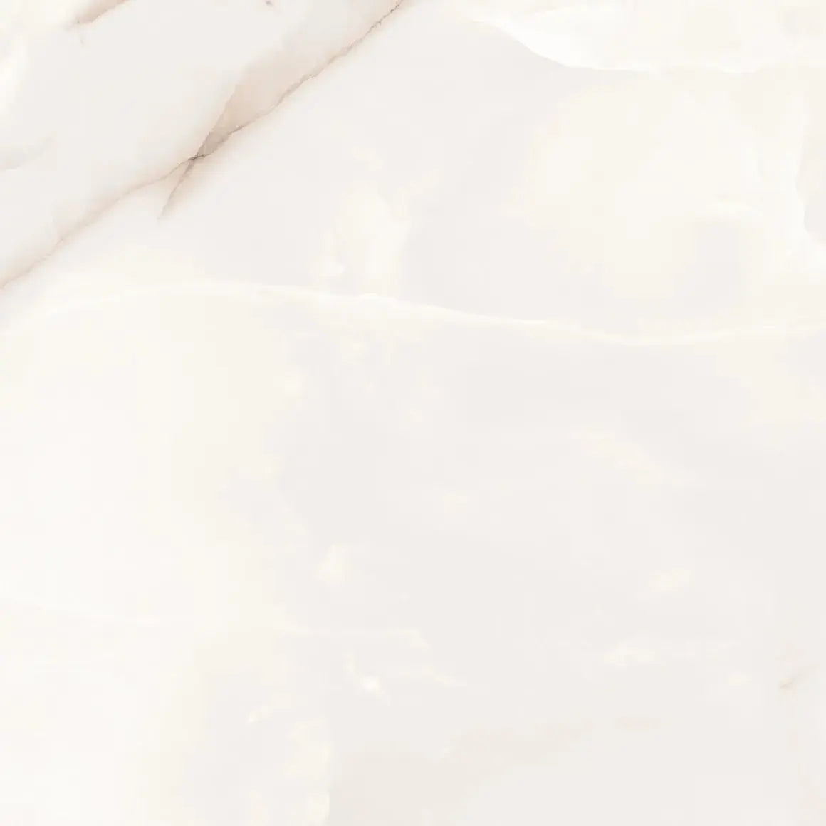 A close-up of a glossy white marble surface with soft cream veining and subtle tonal variation.